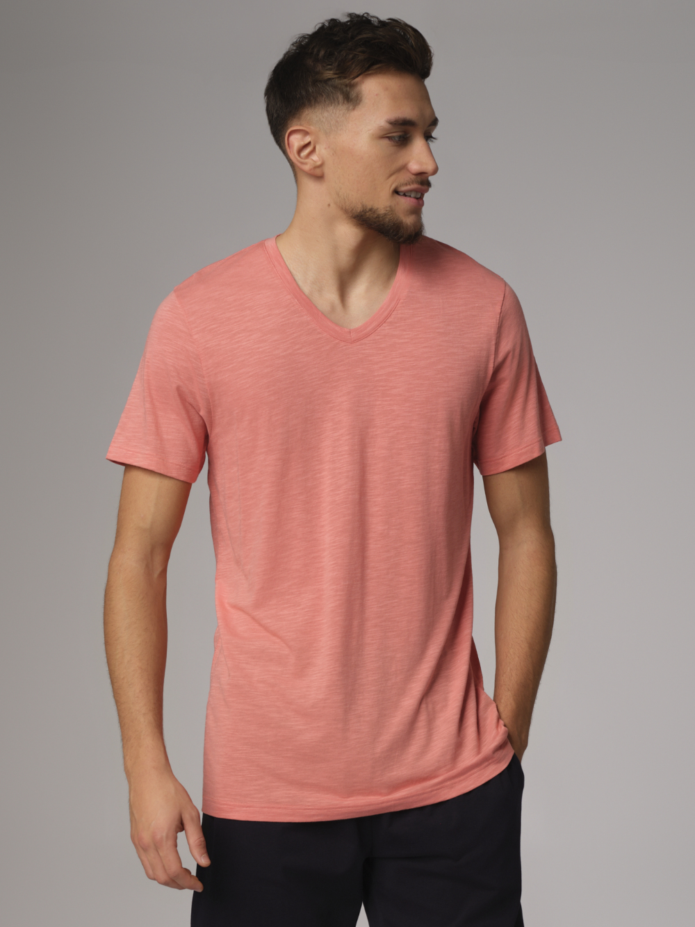 Front view: Man wearing Comazo men's short-sleeve shirt made from slub yarn in papaya color.
