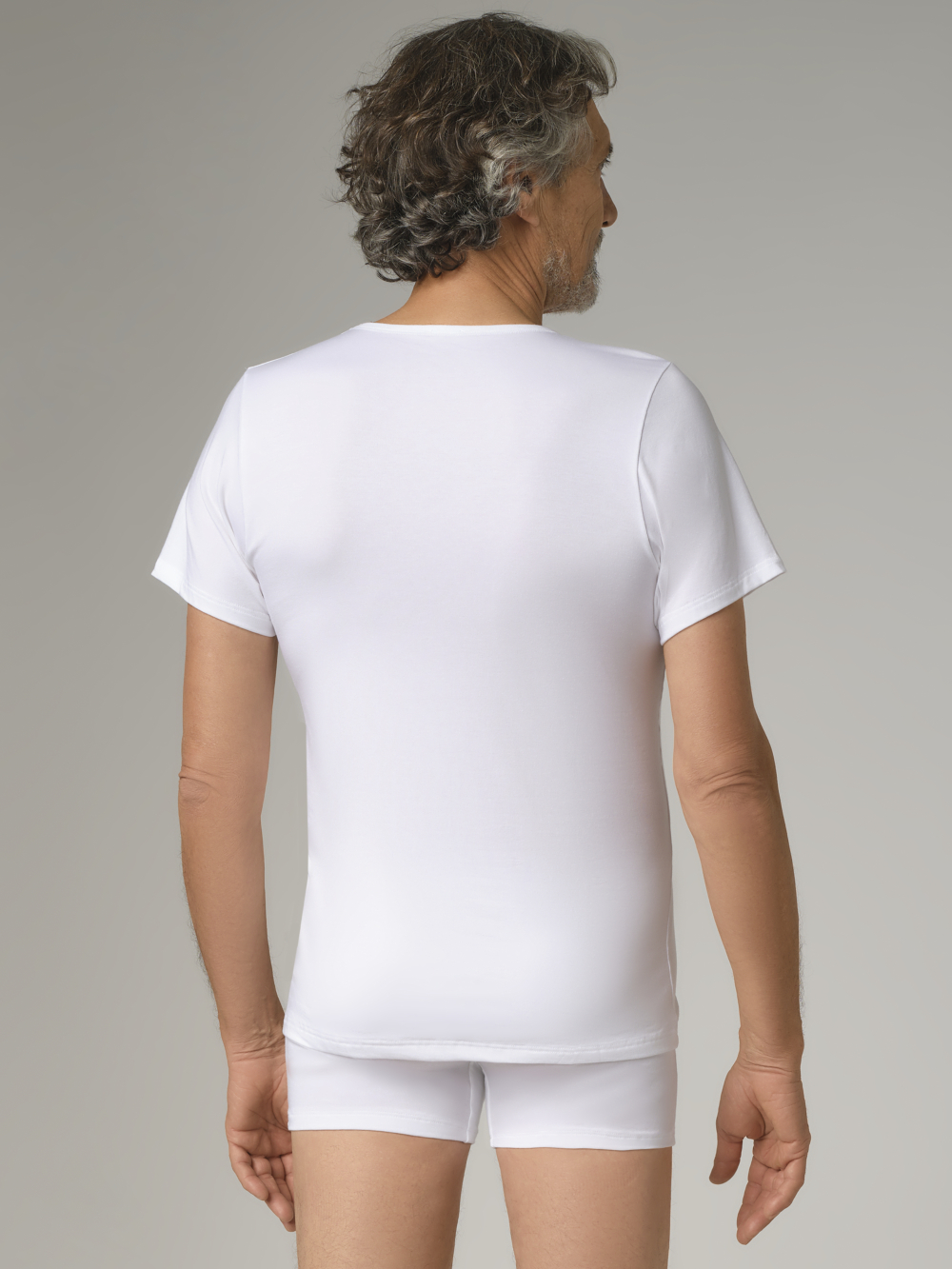 Rückansicht: Mann trägt kurzarm Shirt aus Baumwolle und Micromodal von Comazo in der Farbe Weiß mit V-Ausschnitt