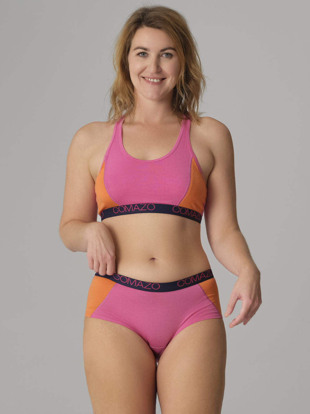 Vorderansicht: Frau trägt Comazo Damen Bustier aus Merinowolle Farbe Pink-Mango