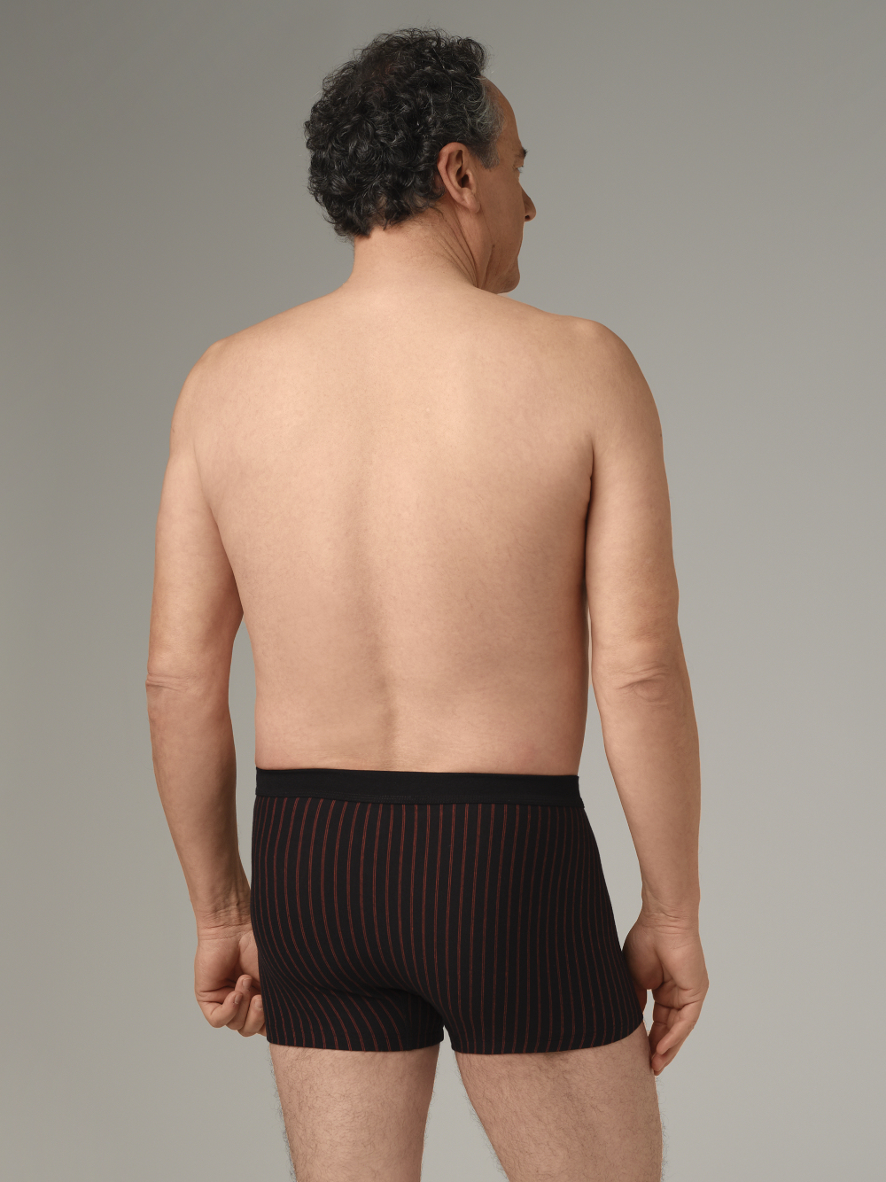 Rückansicht: Mann trägt Trunks von Comazo in der Farbe Schwarz mit Streifen aus 100% Baumwolle