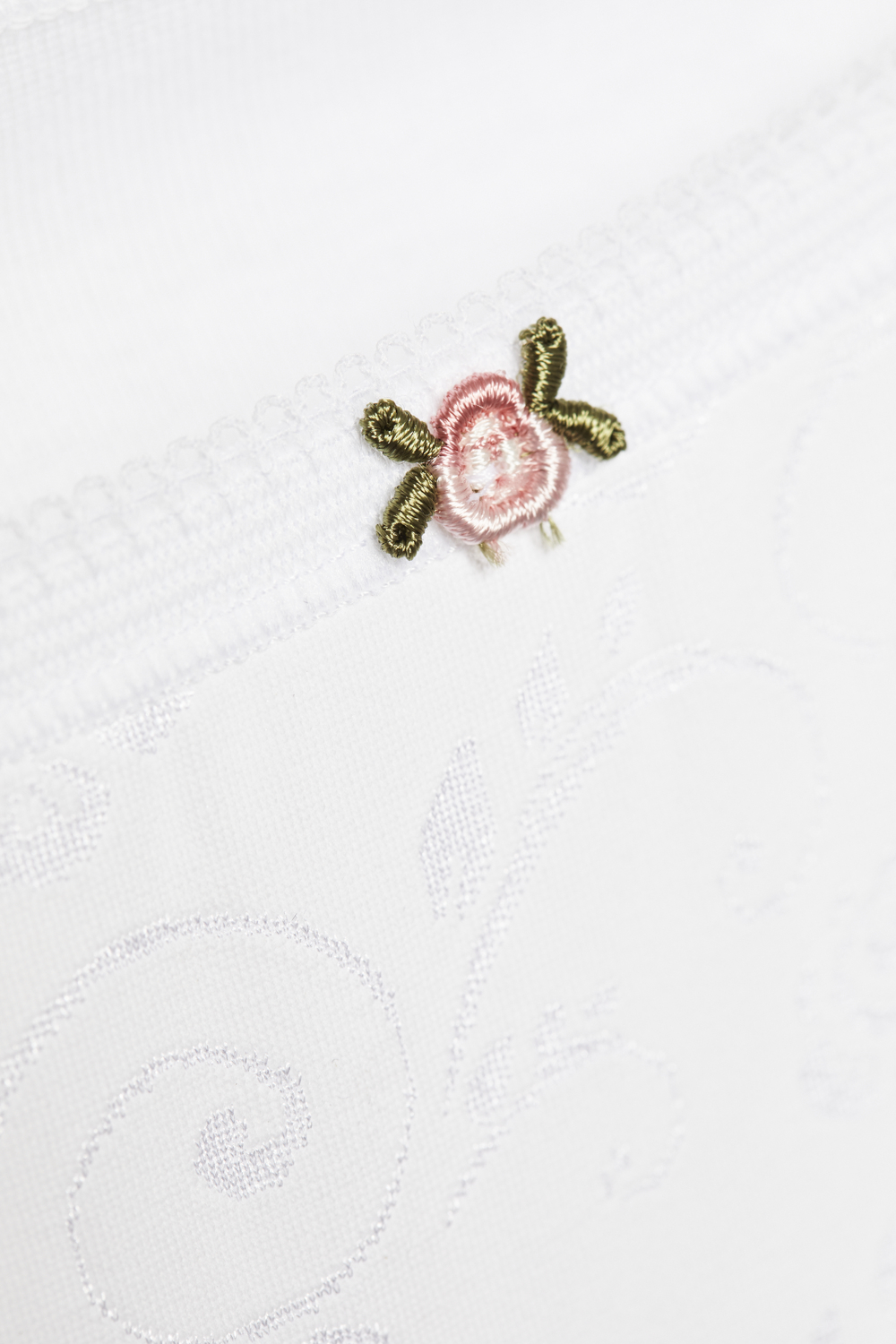 Detailbild Taillen-Slip von Comazo in der Farbe Weiß aus 100% Baumwolle mit zartem Stickblümchen.