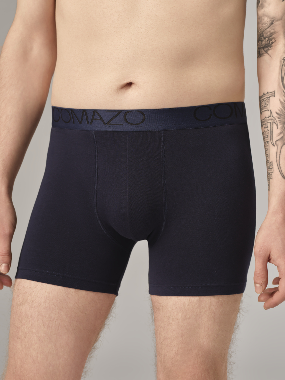 Front view: Man wearing long-leg underwear by Comazo in navy with logo waistband