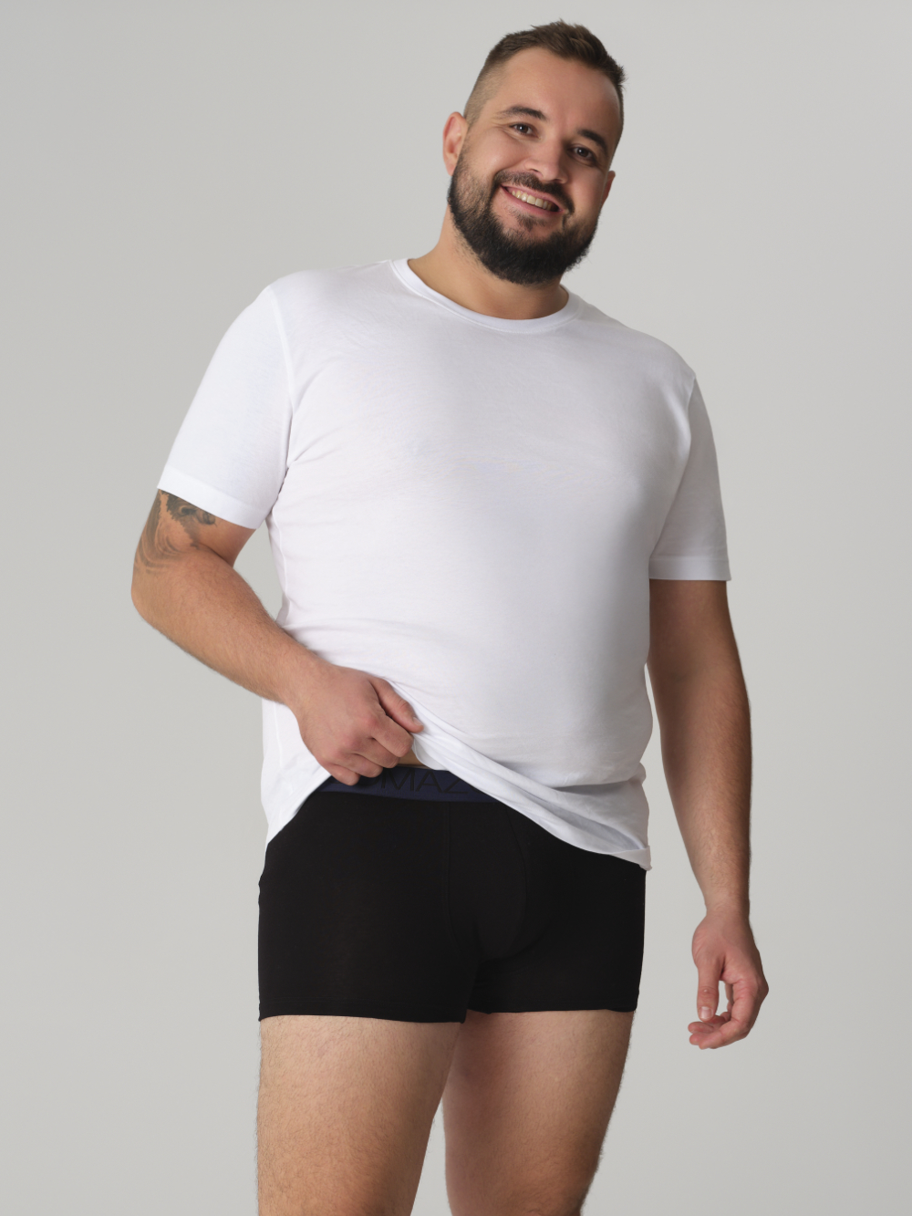 Vorderansicht: Mann trägt Fairtrade Pants von Comazo in der Farbe Black mit Webgummi mit Schriftzug