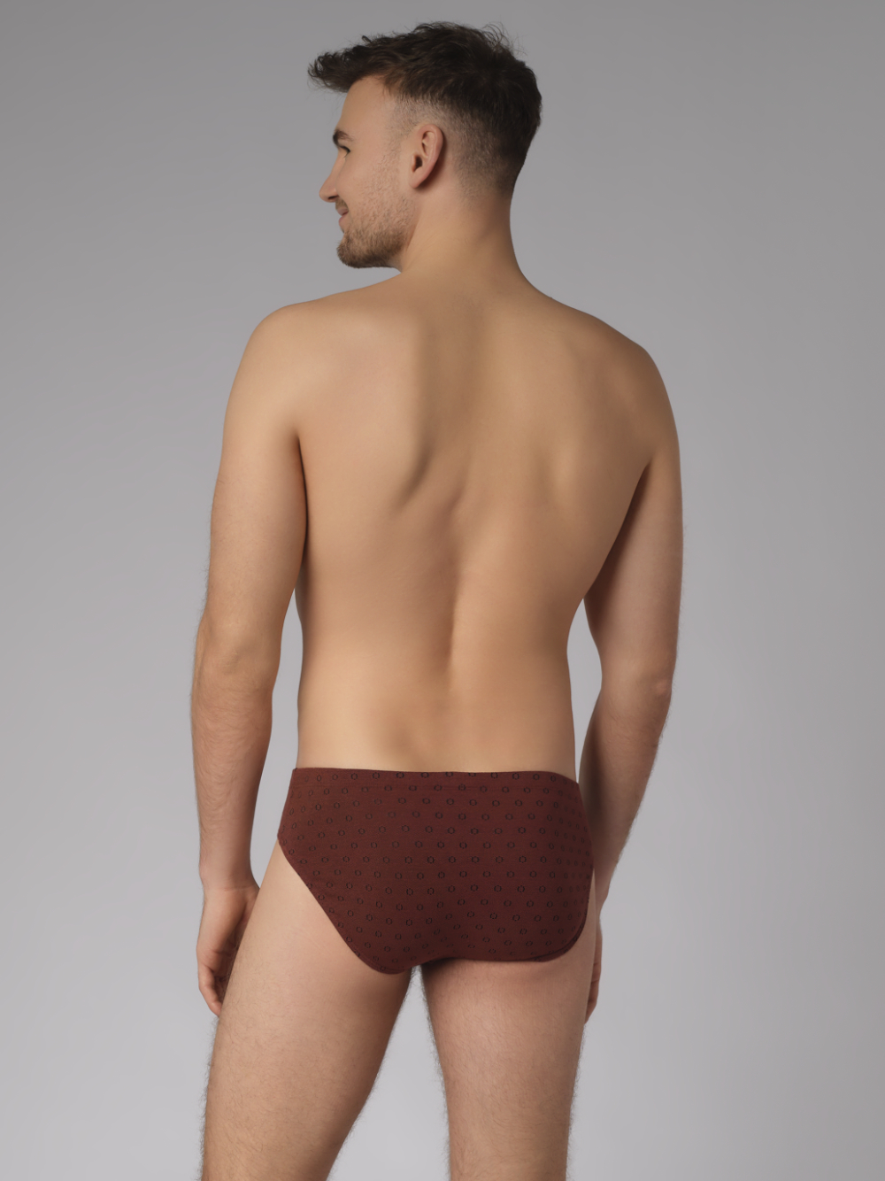 Rückansicht: Mann trägt Slip von Comazo in der Farbe Cognak mit schwarzen Kreisen