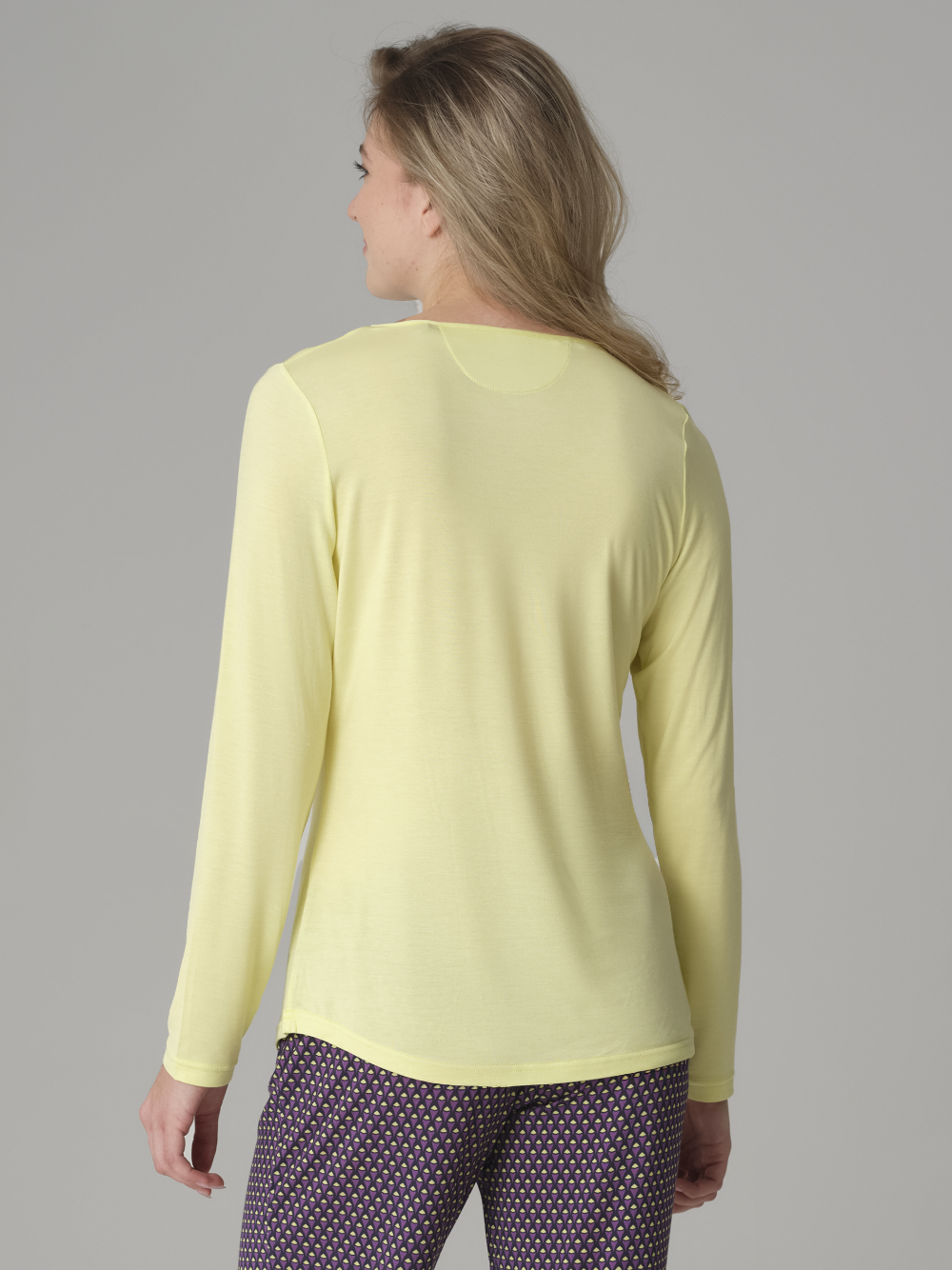 Rückansicht: Frau trägt Comazo Langarm-Schlafshirt aus Micromodal Farbe Pistazie