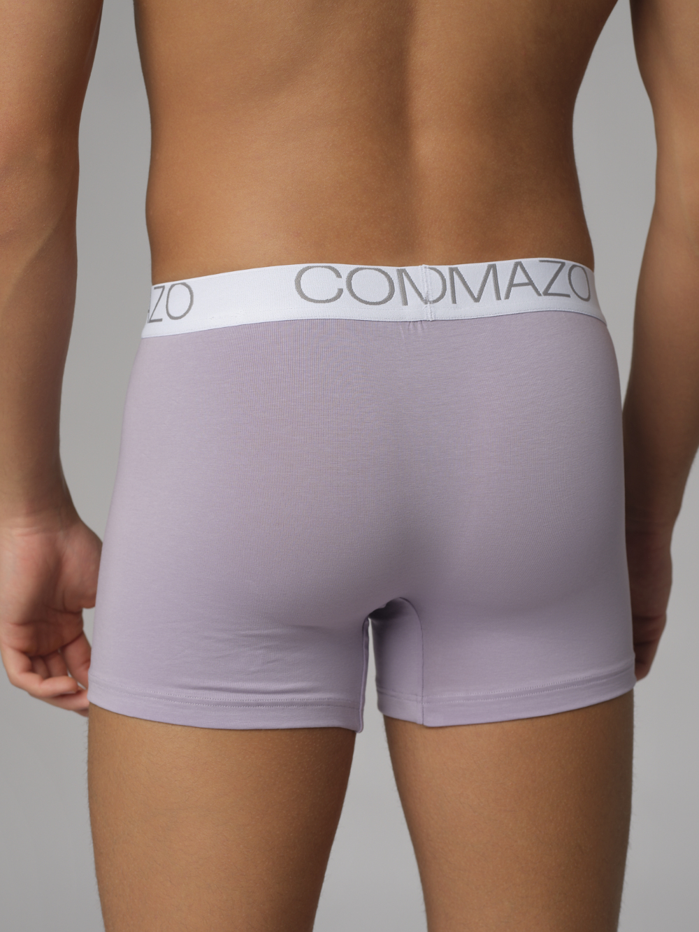 Close-up back view: Man wearing Comazo men's trunks in purple