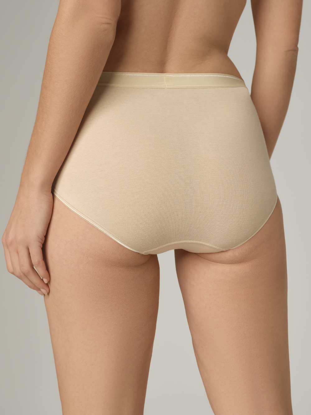 Back view: Woman wearing Comazo maxi slip in Powder, fine rib quality.