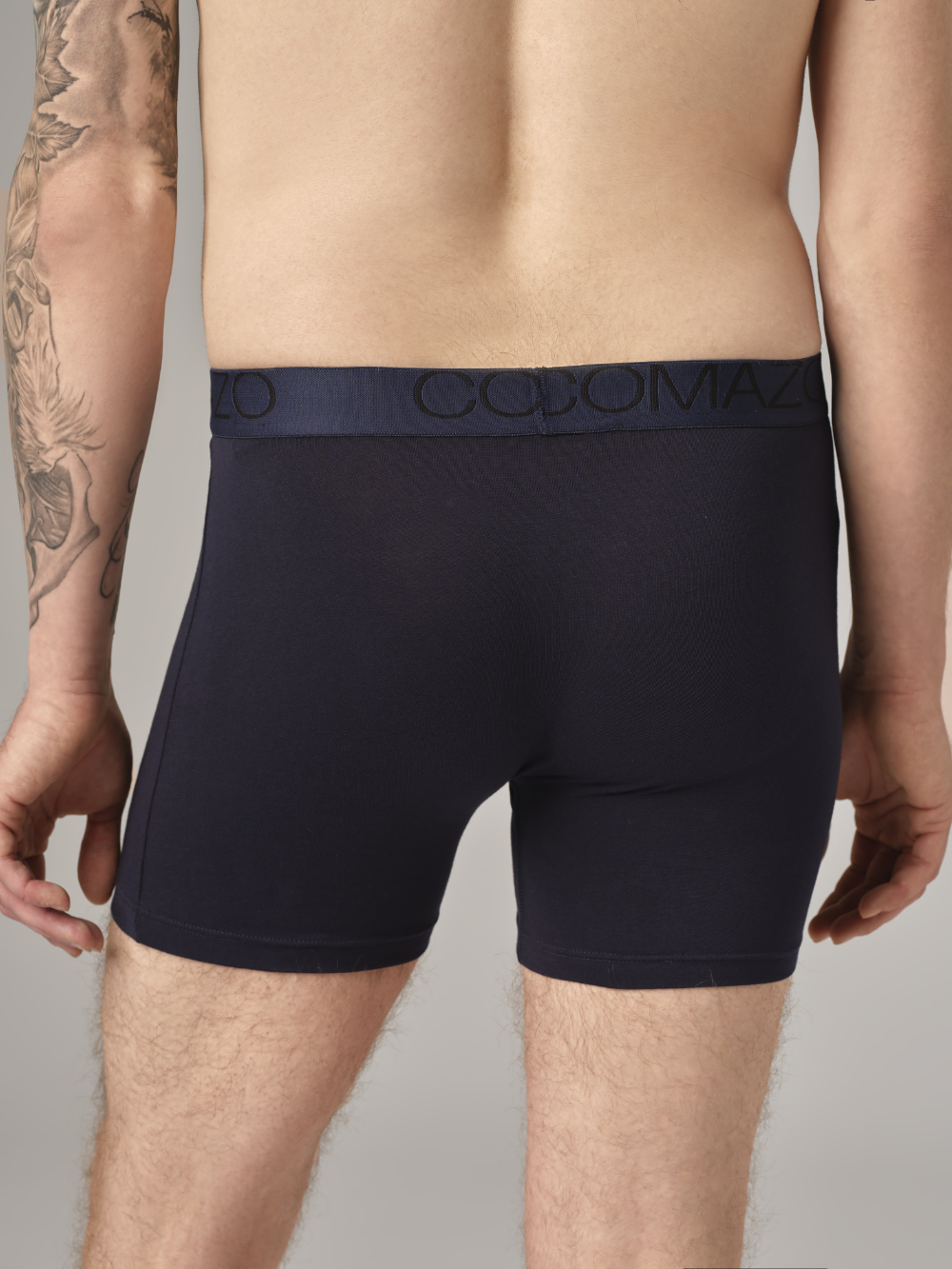 Rear view: Man wearing long-leg underwear by Comazo in navy with logo waistband