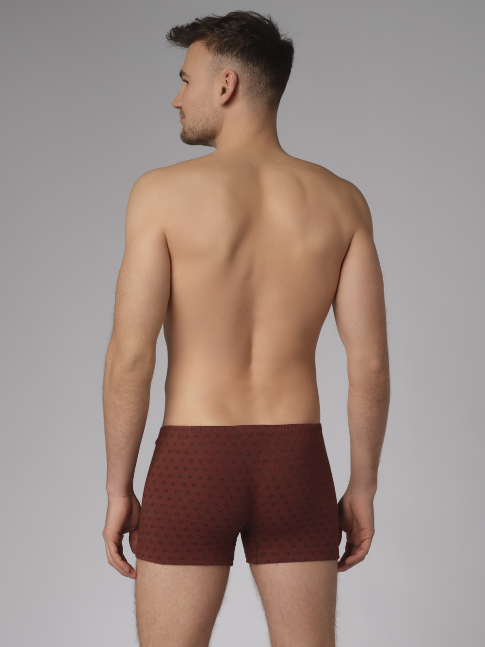 Rückansicht: Mann trägt Trunks von Comazo in der Farbe Cognak mit schwarzen Kreisen