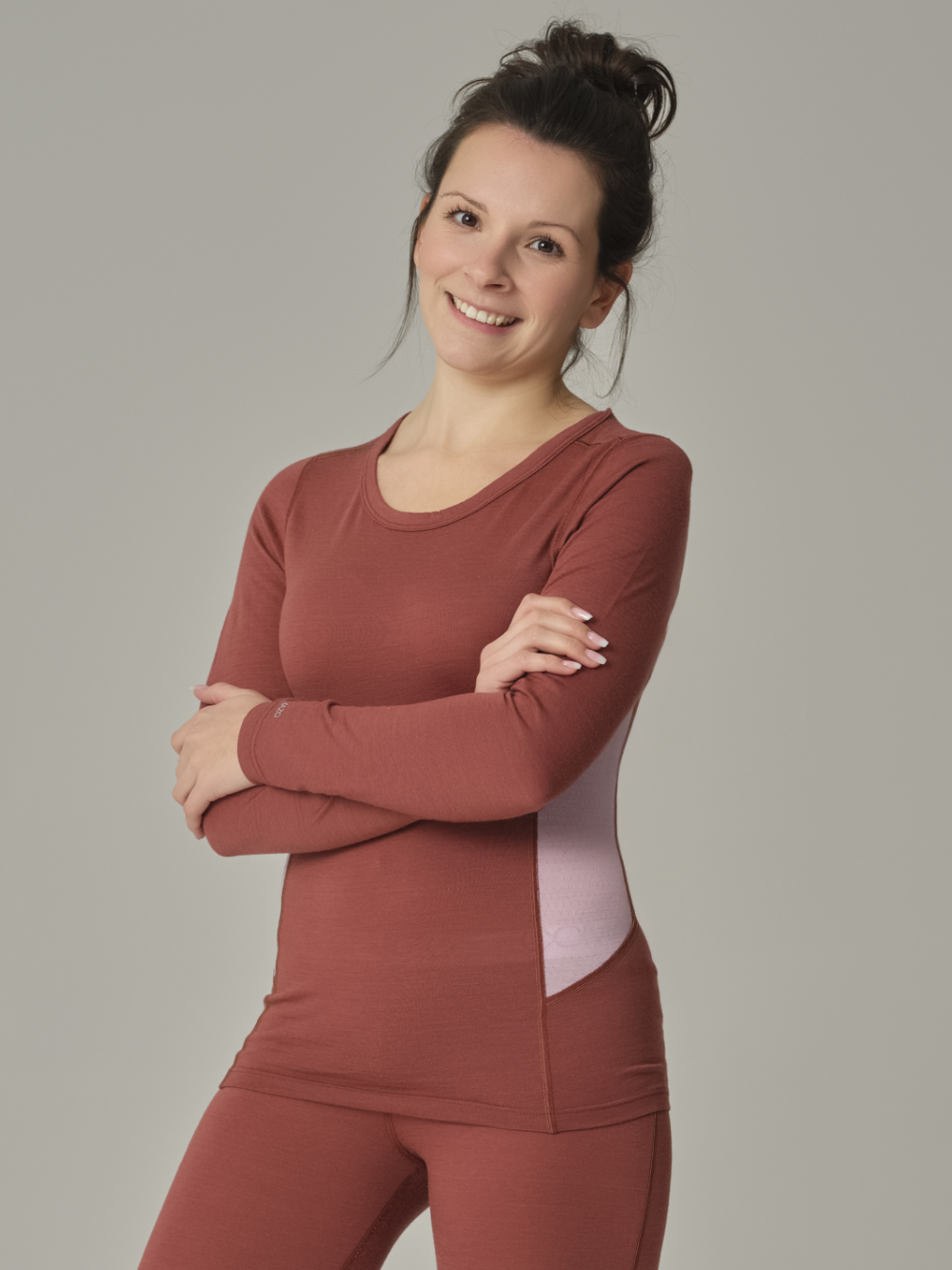 Vorderansicht: Frau trägt Merinowolle-Shirt langarm von Comazo in der Farbe Brandy/Rosegrey aus 100% mulesing-freier Schurwolle mit Mesh-Einsätzen