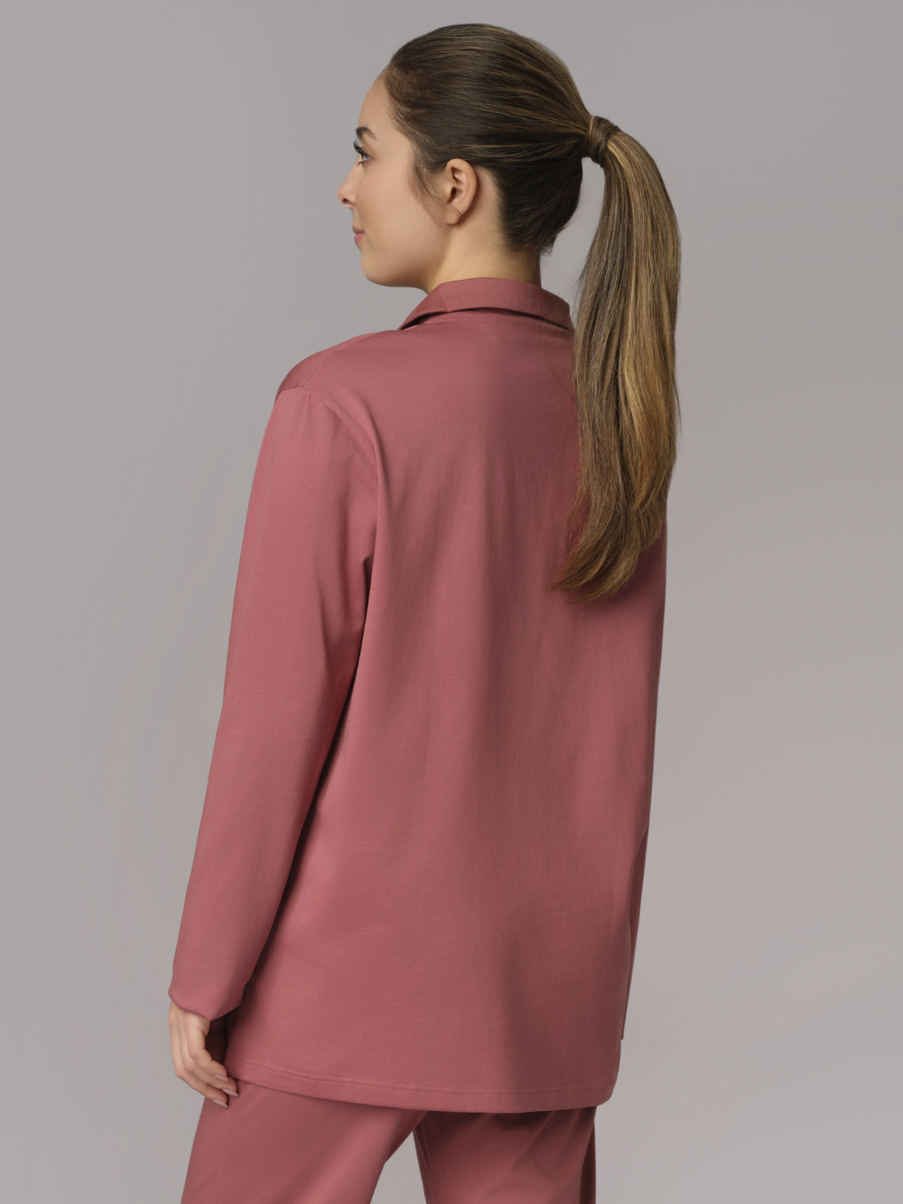 Rückansicht: Frau trägt Pyjamajacke von Comazo in der Farbe Old Rose aus 100% merzerisierter Baumwolle mit Knopfleiste & Brusttasche