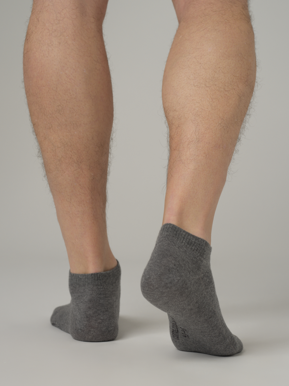 Rückansicht: Mann trägt Sneaker Socken von Comazo in der Farbe Grau-Melange mit Komfortbund