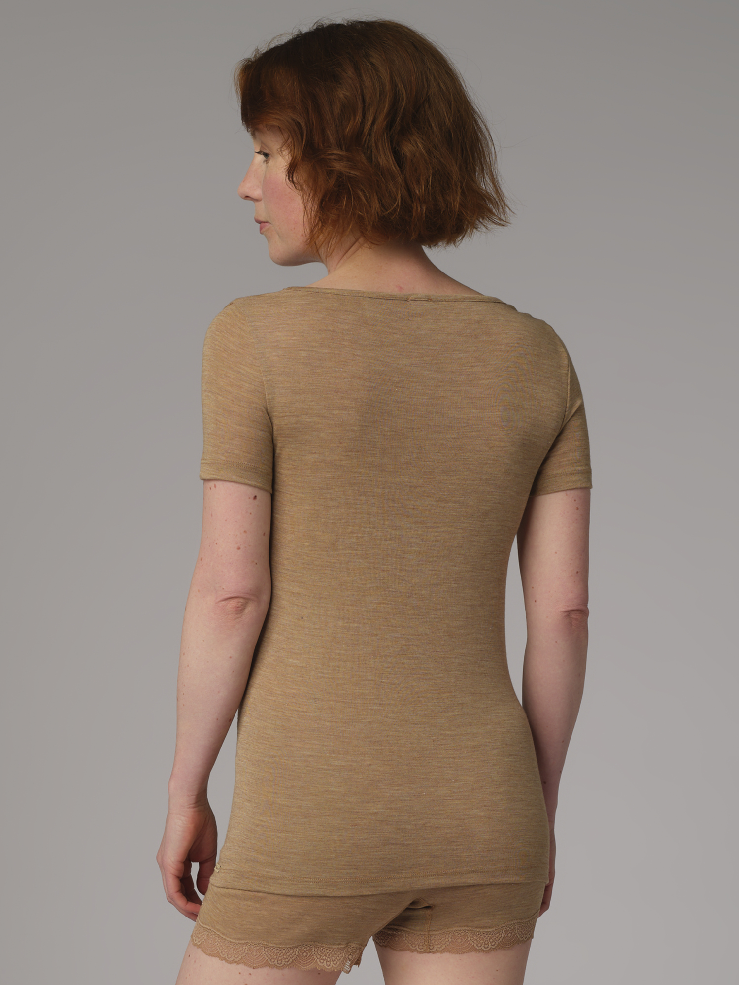 Rückansicht: Frau trägt Shirt kurzarm aus Wolle-Seide in der Farbe Camel mit V-Ausschnitt mit feiner Spitze