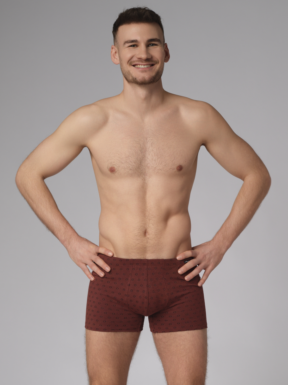 Vorderansicht: Mann trägt Trunks von Comazo in der Farbe Cognak mit schwarzen Kreisen