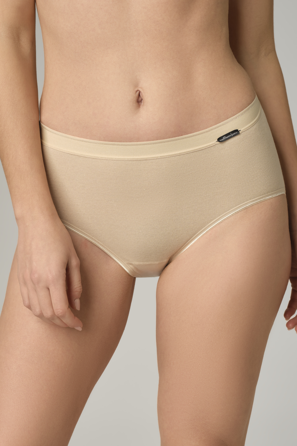 Vorderansicht: Frau trägt Maxi-Slip von Comazo in der Farbe Puder Feinripp-Qualität