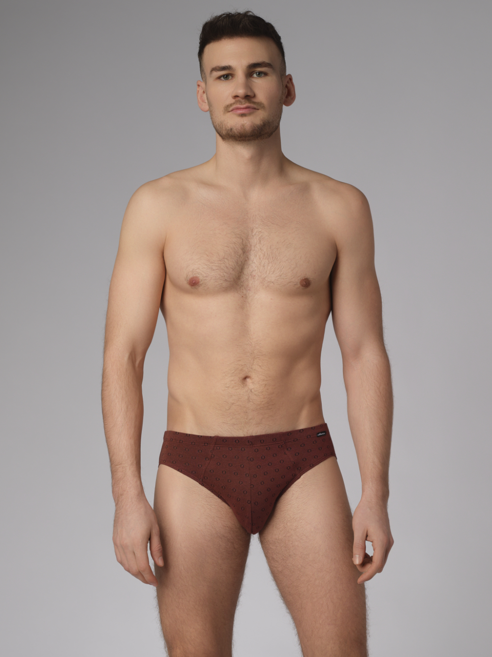Vorderansicht: Mann trägt Slip von Comazo in der Farbe Cognak mit schwarzen Kreisen