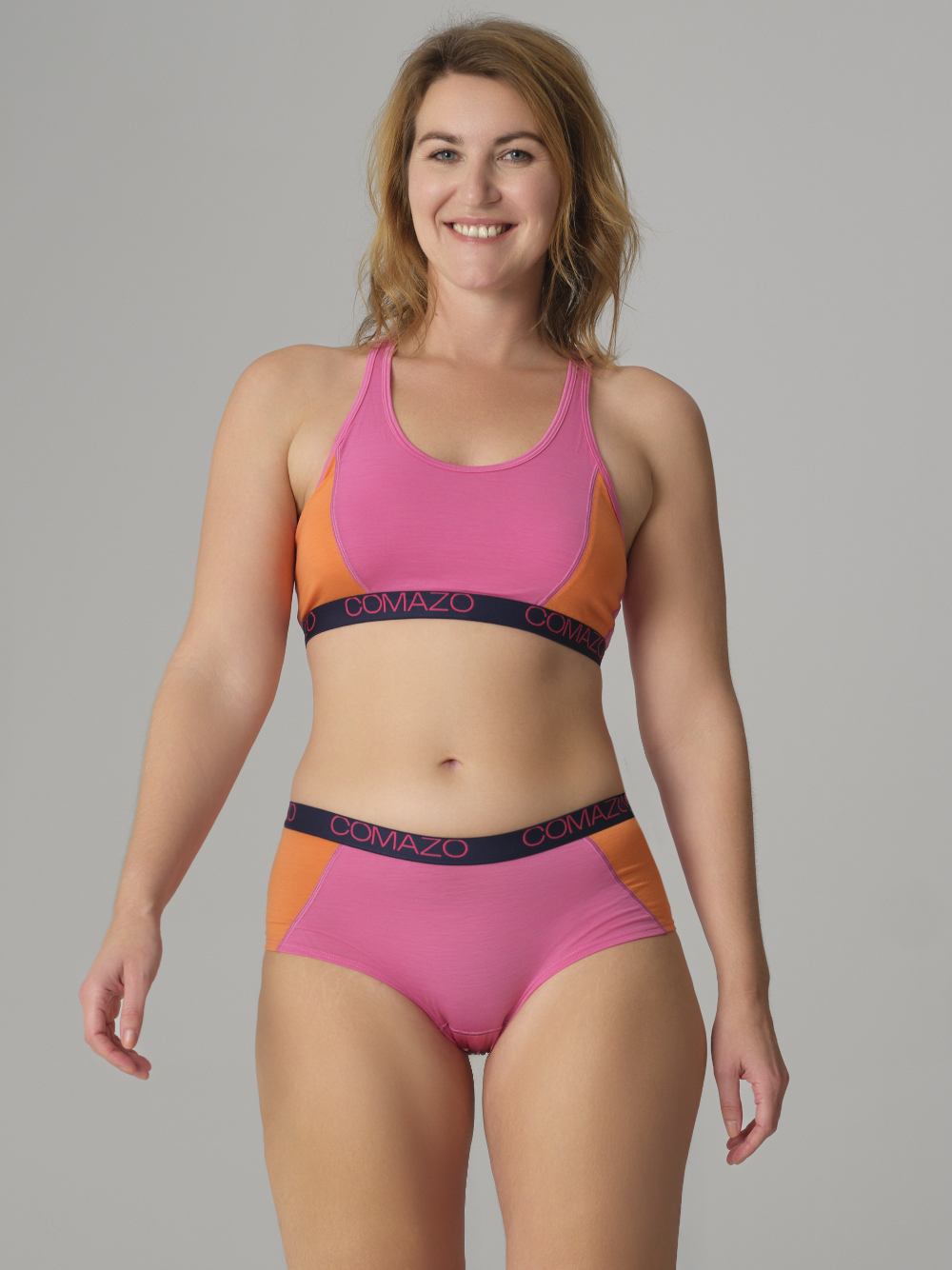 Vorderansicht: Frau trägt Comazo Panty aus Merinowolle Farbe Pink-Mango
