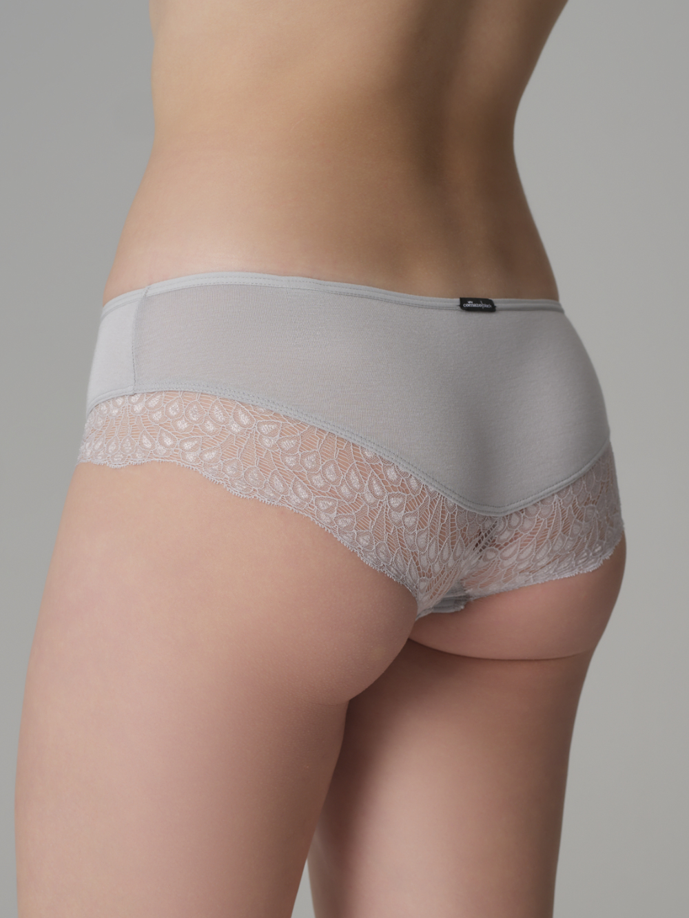 Rückansicht: Frau trägt Comazo Slip mit Spitzen-Details Farbe Silber