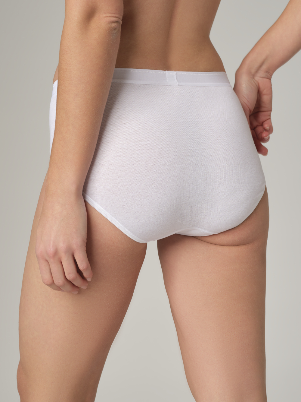 Rückansicht: Frau trägt Maxi-Slip von Comazo in der Farbe Weiß Feinripp-Qualität