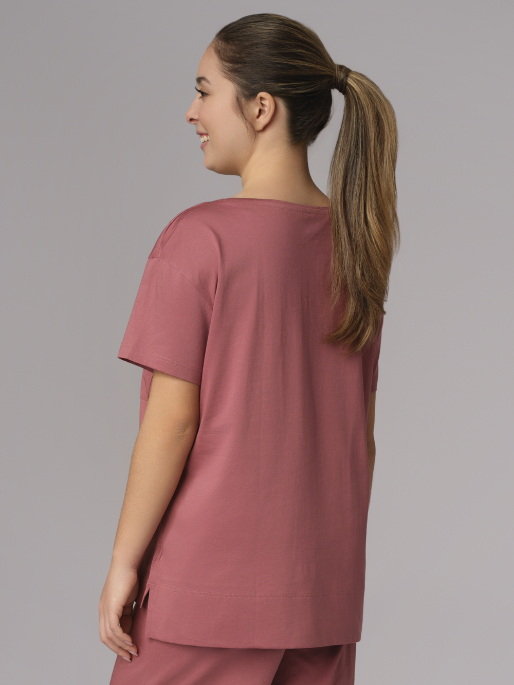 Rückansicht: Frau trägt Schlafshirt von Comazo in der Farbe Old Rose aus 100% merzerisierter Baumwolle mit Rundhalsausschnitt & Brusttasche