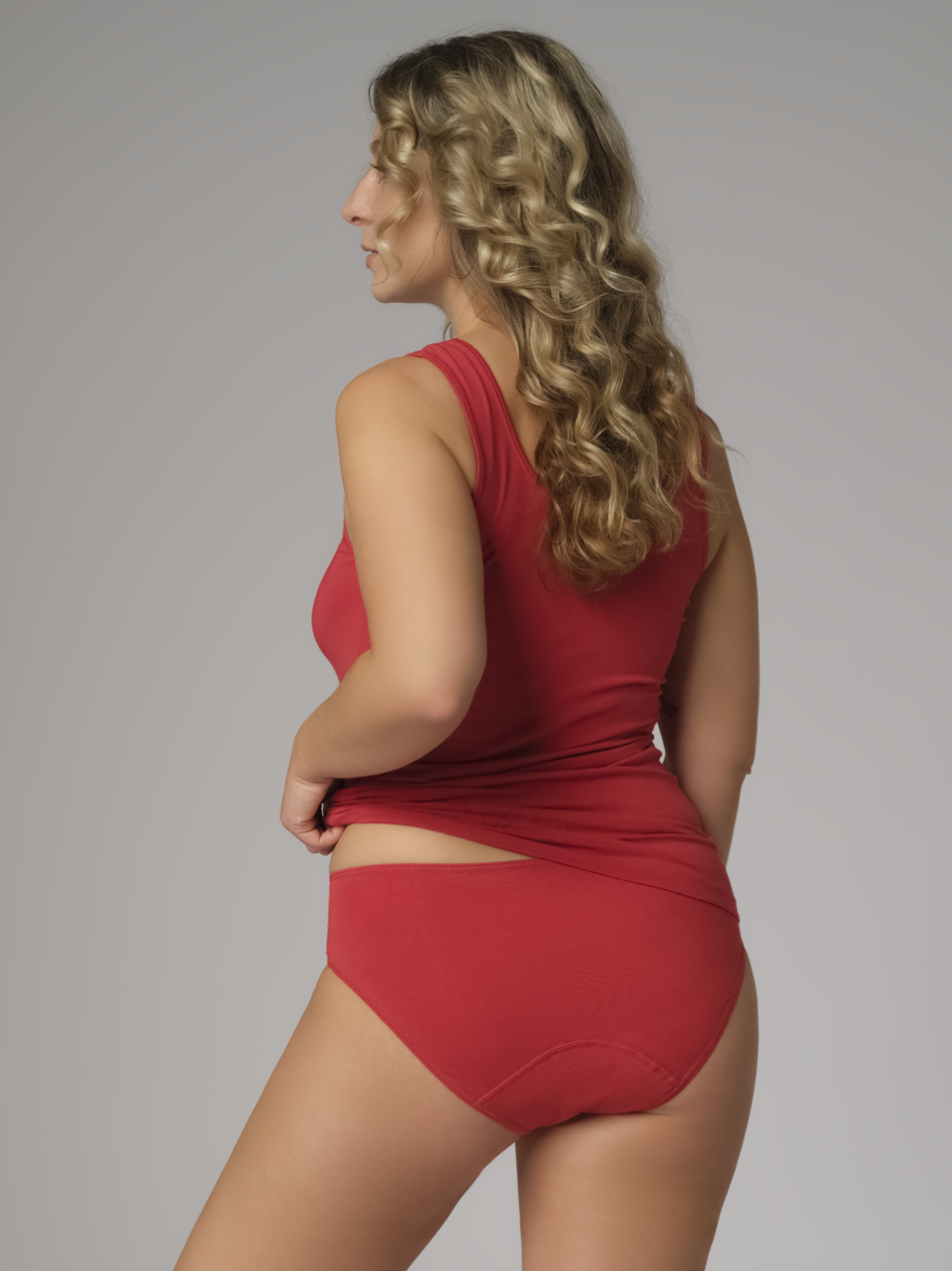 Rückansicht: Frau trägt Comazo Damen Fairtrade Perioden-Slip "Medium" Farbe Cranberry