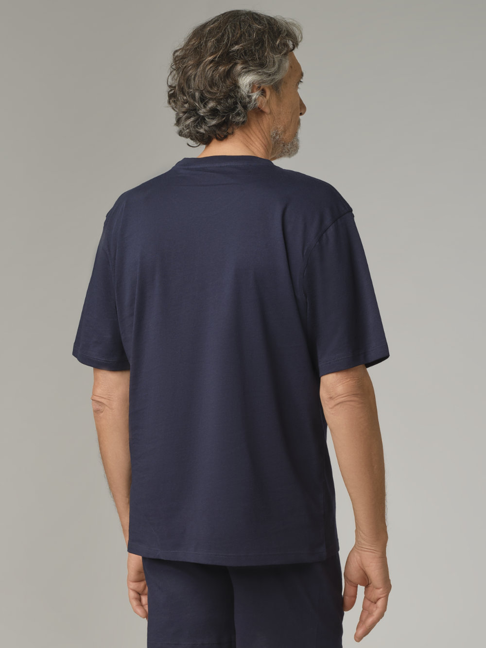 Rear view: Man wearing Comazo American Style T-shirt in Marine color, made of 100% cotton, featuring a crew neck with ribbed collar.