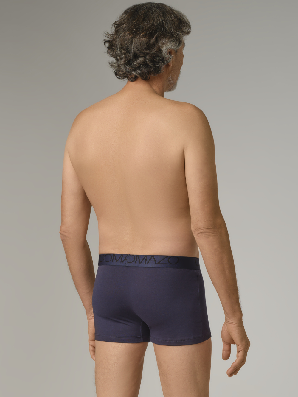 Rear view: Man wearing short pants by Comazo in navy with logo waistband