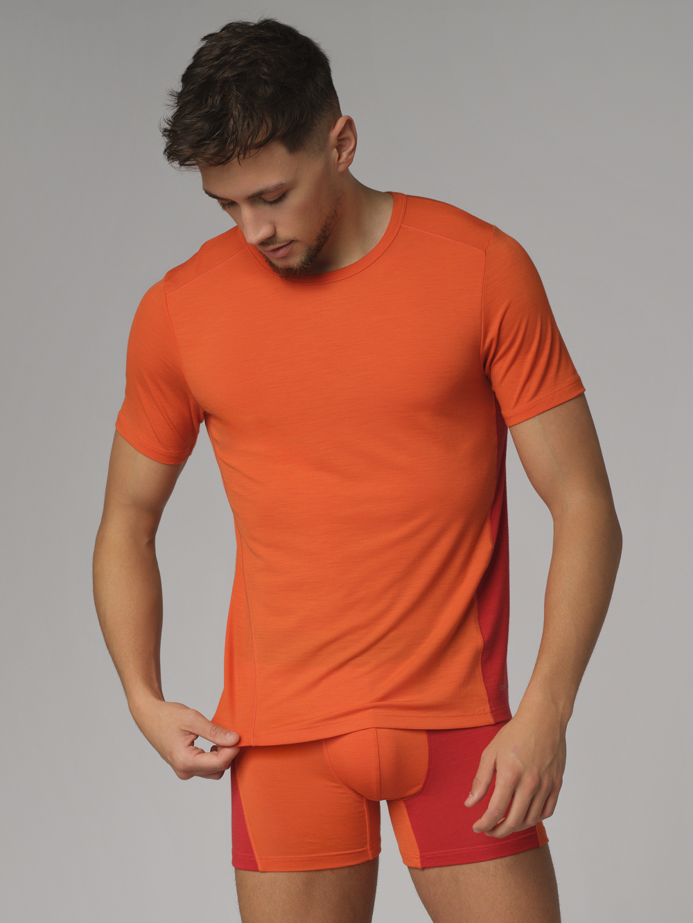 Vorderansicht: Mann trägt Comazo Herren Shirt kurzarm aus Merinowolle Farbe Orange/Granat