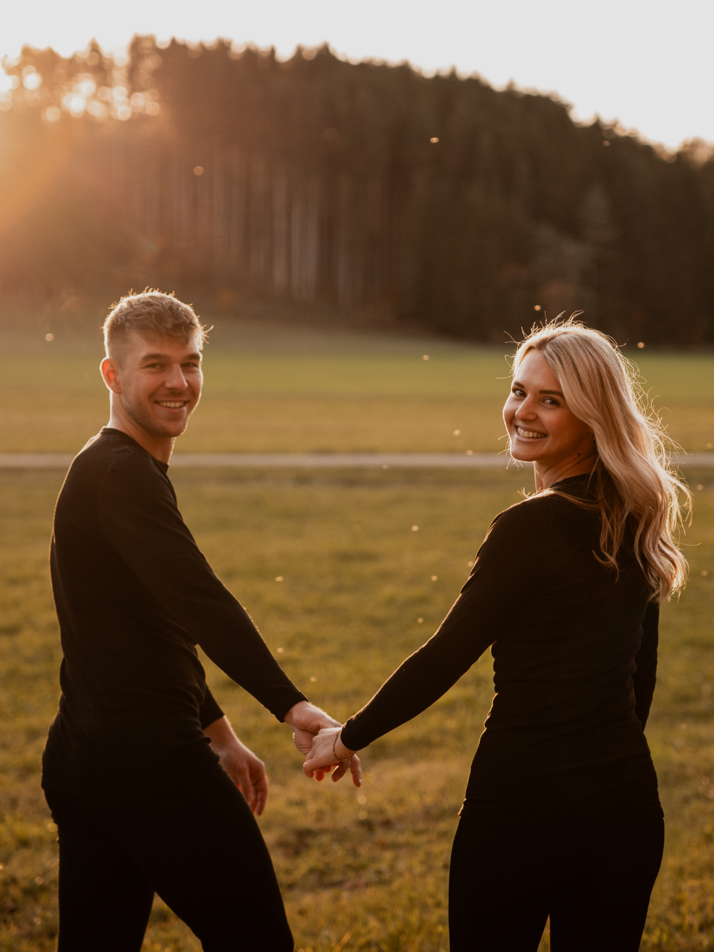 Paar trägt schwarze Unisex-Funktionswäsche von Comazo bei einem Spaziergang – atmungsaktive und temperaturregulierende Basics für jedes Wetter